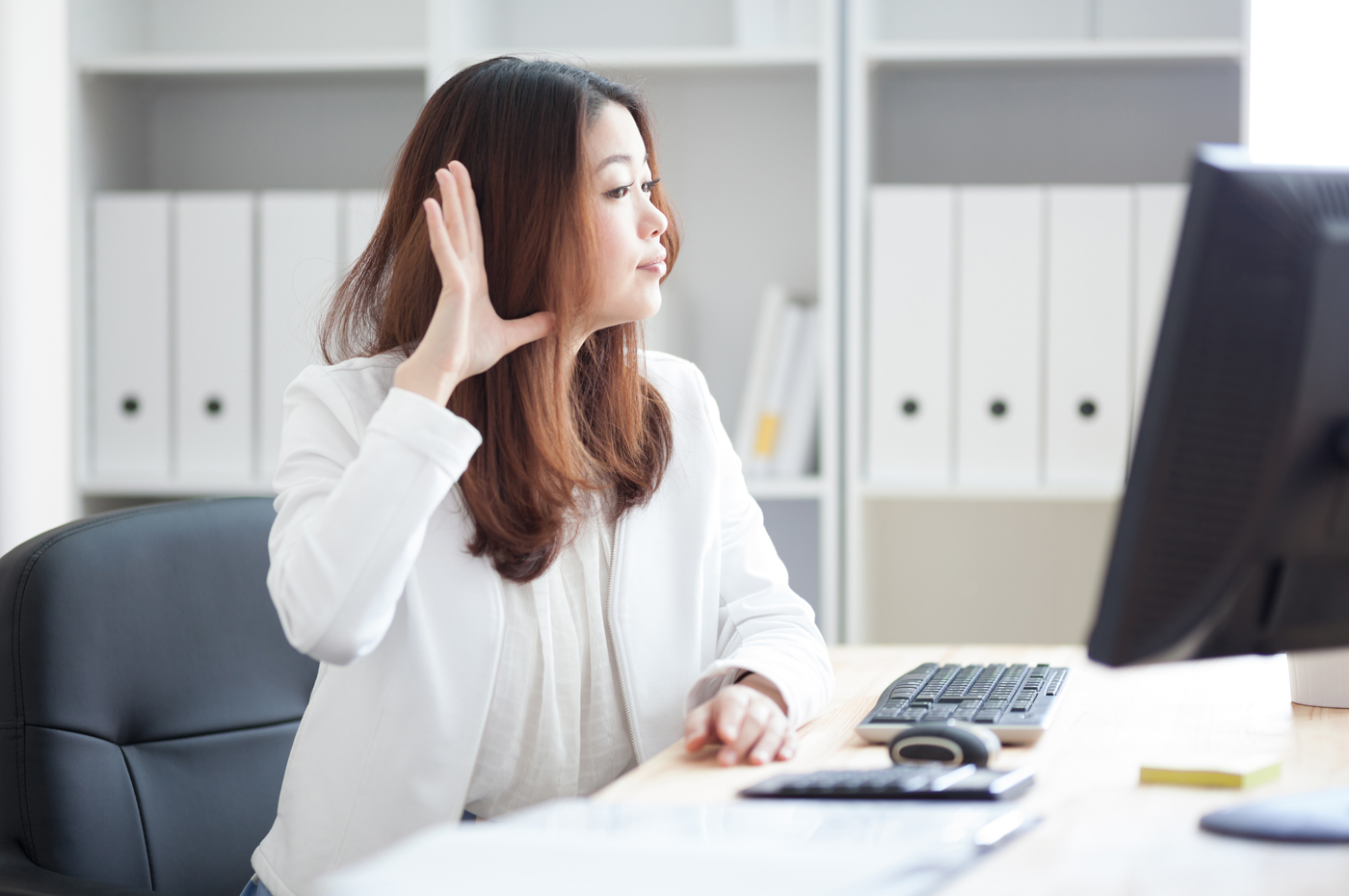 耳に手を当てる女性
