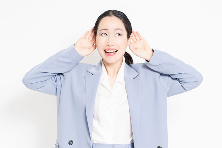 耳に手を当てる人